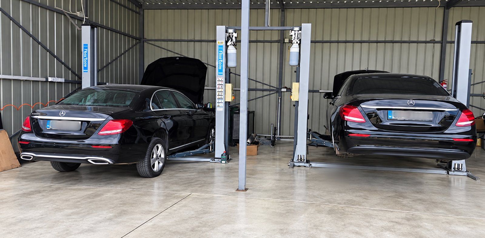 Zwei Mercedes E-Klasse auf Hebebühnen in der Werkstatt
